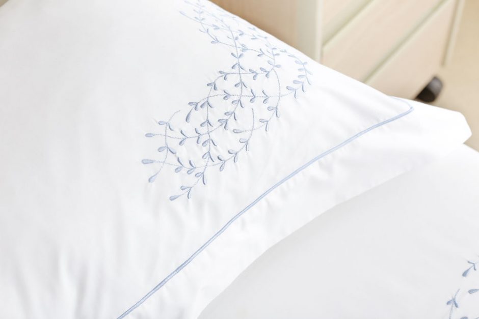 roupa de cama bordada com flores azuis